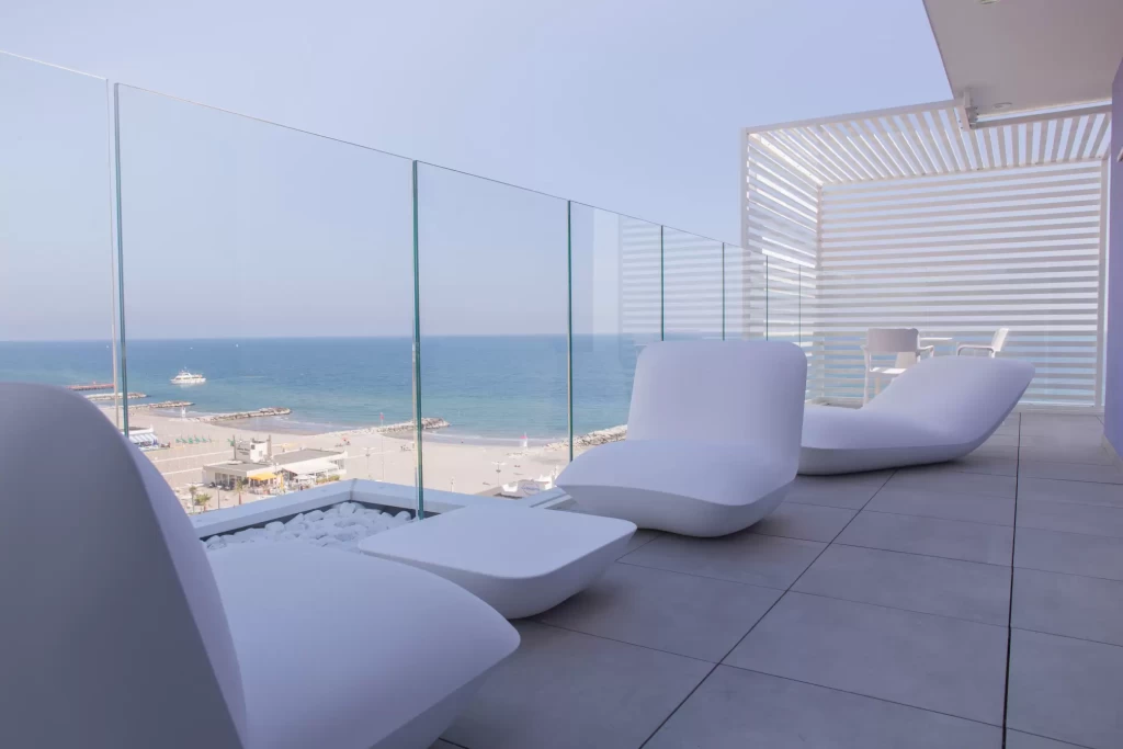 Terrazza moderna con mobili bianchi e vista sul mare.
