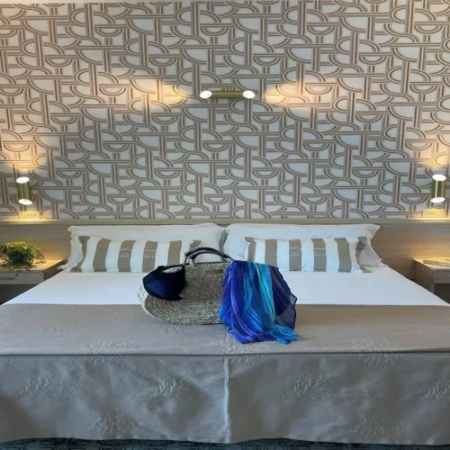 Letto matrimoniale elegante con decorazioni sobrie e una borsa sopra.