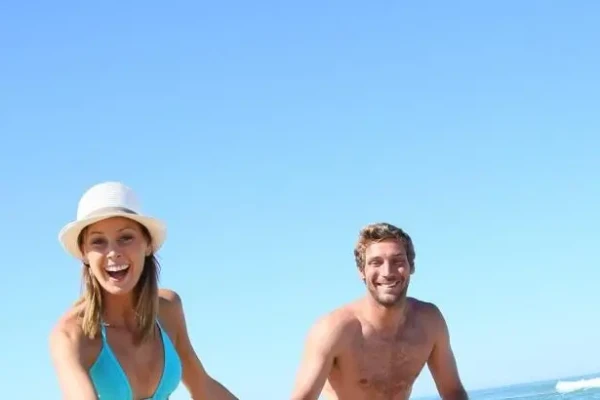 Ein lächelndes Paar genießt einen sonnigen Tag am Strand.