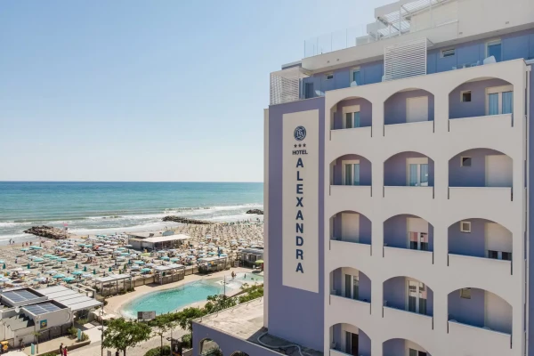 Hotel am Strand mit dem Namen "ALEXANDRA" und Blick auf das Meer.