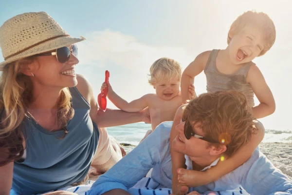 Eine gl&uuml;ckliche Familie genie&szlig;t einen sonnigen Tag am Strand.